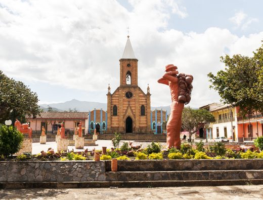 Parque Principal Ráquira Boyacá con iglesia y esculturas de arcilla, capital artesanal de Colombia.