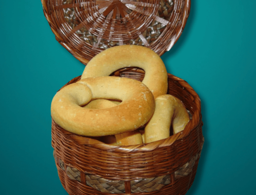 Pan de maíz boyacense artesanal recién horneado sobre tabla de madera, elaborado con harina de maíz blanco y queso campesino.