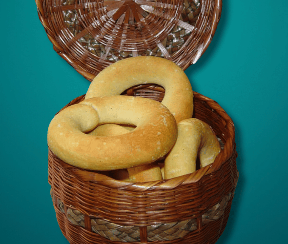 Pan de maíz boyacense artesanal recién horneado sobre tabla de madera, elaborado con harina de maíz blanco y queso campesino.