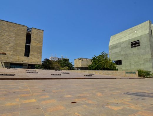 Fachada moderna del Museo del Caribe en Barranquilla, con edificio de piedra clara, fuentes de agua y plaza arbolada bajo cielo azul