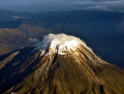 Nevado del Tolima con su cono volcánico nevado elevándose sobre un paisaje de páramo con frailejones y pajonales en el Parque Nacional Natural Los Nevados.