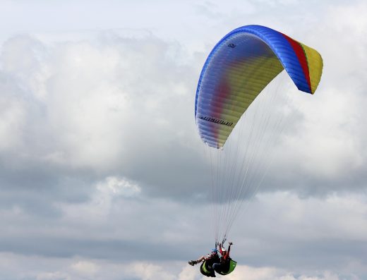 Persona volando en parapente sobre el Cañón del Chicamocha en San Gil Santander con vista panorámica de montañas