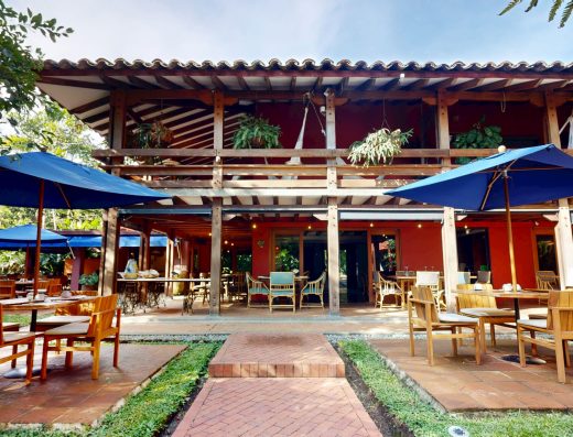 Vista aérea de Sazagua Hotel Boutique en Pereira con piscina azul, jardines tropicales, palmeras y edificios de arquitectura colonial